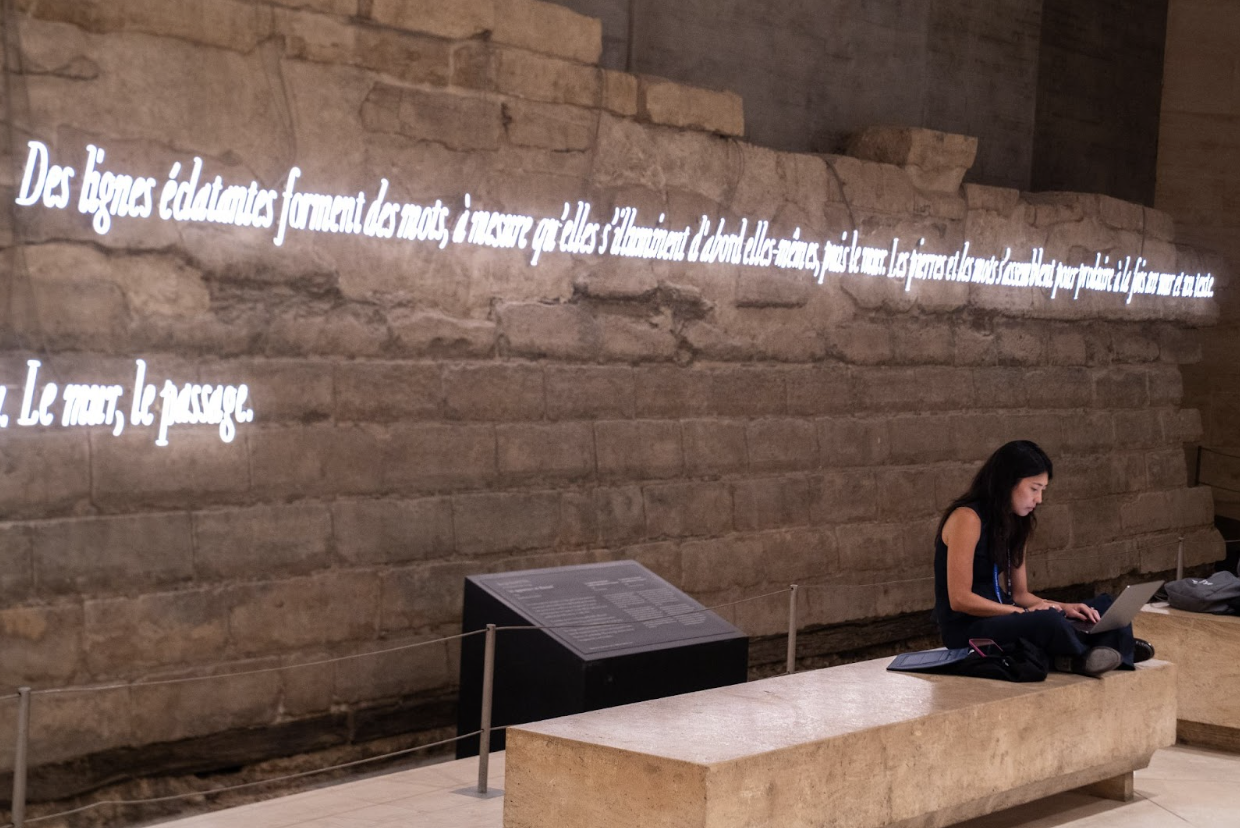 “Brilliant lines form words, as they first illuminate themselves, then the wall. The stones and the words come together to produce both a wall and a text.”